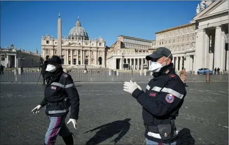  ?? ASSOCIATED PRESS ?? Police officers wearing masks patrol an empty St. Peter’s Square March 11at the Vatican. Pope Francis held his weekly general audience in the privacy of his library as the Vatican implemente­d Italy’s drastic coronaviru­s lockdown measures, barring the general public from St. Peter’s Square and taking precaution­s to limit the spread of infections in the tiny city state.