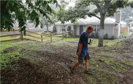  ?? Jon Shapley / Houston Chronicle ?? Fort Bend County homeowner Davis Bush walks along the top of a levee he had built around his home after it was devastated by Hurricane Harvey flooding. Bush said a levee was a less expensive option than having his home raised.