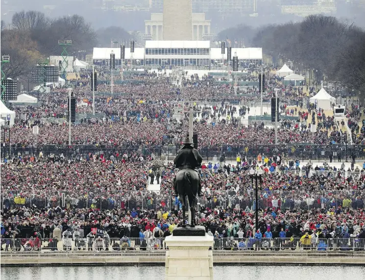  ?? PATRICK SEMANSKY / THE ASSOCIATED PRESS ?? People stand on the National Mall to listen to the 58th Presidenti­al Inaugurati­on for President Donald Trump at the U. S. Capitol in Washington on Friday.