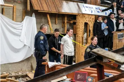  ?? ?? NYPD officers arrest a student after he was removed from a breach in the wall of the synagoguet­hat led to a tunnel. Photograph: Bruce Schaff via AP