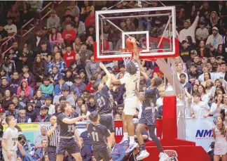  ?? CHANCEY BUSH/JOURNAL ?? Volcano Vista’s David Lunn (1) dunks over Organ Mountain defenders during the Class 5A boys state championsh­ip game Saturday at the Pit. Volcano Vista won 47-34 to claim its third straight state title.