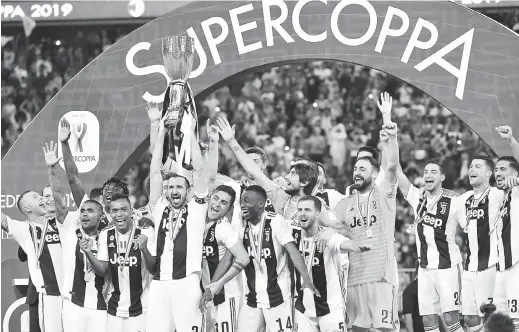  ?? — Gambar Reuters ?? KEJUARAAN KELAPAN: Chiellini menjulang trofi kejuaraan ketika meraikan kejayaan Juve menjuarai Piala Super selepas tamat perlawanan di Jeddah, Arab Saudi kel marin.