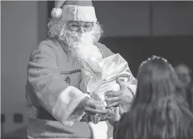  ?? NATHAN J FISH/THE OKLAHOMAN FILE ?? Indigenous Santa gives out candy to children during the 2022 Winter Holiday Art Market at the First Americans Museum in Oklahoma City.