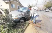  ?? LAURA A. ODA/STAFF ?? Ricardo Juarez digs his van out of the mud to try to move it off the sidewalk where it had floated on South 20th Street.