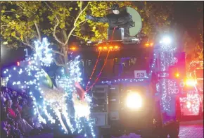  ??  ?? Lodi Police Chief Tod Patterson, dressed as Batman, waves from the BATT during the Parade of Lights in Downtown Lodi on Thursday.