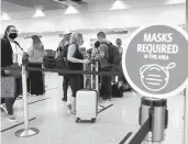  ?? JOE RAEDLE/GETTY ?? Travelers wait in line to check in for a flight out of Miami Internatio­nal Airport in February.