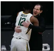  ?? More photos available at arkansason­line.com/44ncaa2. (AP/Michael Conroy) ?? Baylor Coach Scott Drew (right) hugs Bears guard Jared Butler in the closing minutes of their victory over Houston on Saturday in the national semifinals at Indianapol­is.