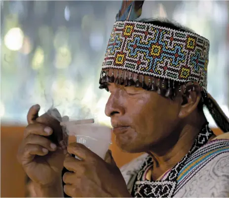  ?? CITIZEN NEWS SERVICE PHOTOS ?? Above, Shaman Pablo Flores prepares to drink ayahuasca during a session in Nuevo Egipto, a remote village in the Peruvian Amazon. Indigenous tribes have longed used the brew as a way to ward off evil spells, and even as a way to hurt their enemies....