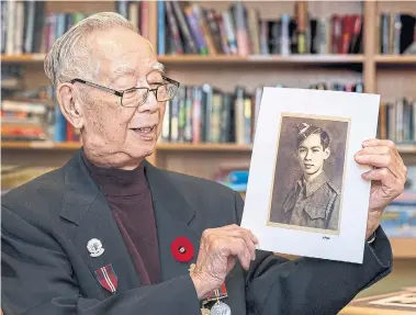  ?? ANDREW FRANCIS WALLACE TORONTO STAR ?? Second World War veteran Hank Wong , 99, holds a picture of himself from 1940, when he volunteere­d for the army.