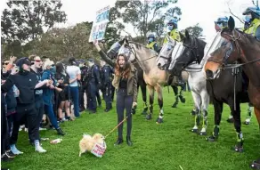  ?? — AFP ?? Raising a ruckus: Protesters confrontin­g police at the Shrine of Remembranc­e in Melbourne during an anti-lockdown rally.