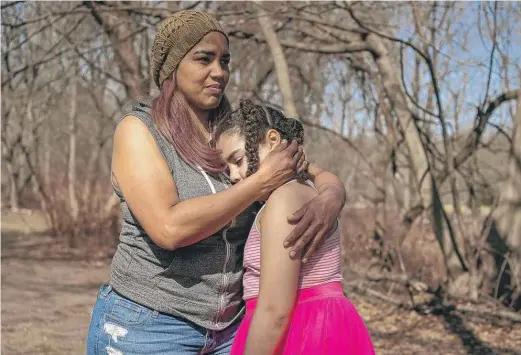  ?? CAROLINE GUTMAN/KHN ?? Alexandra Sierra and one of her daughters hug outside their home in Bergen County, New Jersey.