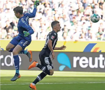  ?? FOTO: DPA ?? Auf dem Weg zur Zweistelli­gkeit: Thorgan Hazard legt den Ball mit dem Kopf vorbei an Freiburgs Torhüter Alexander Schwolow und trifft kurz darauf zum 1:0 für die Borussen.