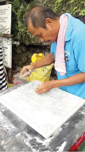  ?? SUNSTAR FOTO / JEANDIE O. GALOLO ?? SET IN
STONE. Eddie Abregana has been carving tombstones outside the Carreta Cemetery for nearly 40 years. He learned the skill when he was 16 years old.