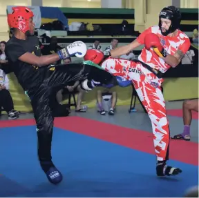  ?? PHOTO BY ASHLEY ANGUIN ?? Jamaica Taekwon-Do Centre’s Nicholas Dusard (left) and England’s Leon Thompson battle in an intense match in the men’s 18-35 Semi-Contact 71kg division of the recently concluded Internatio­nal Sports Kickboxing Associatio­n Amateur Members’ Associatio­n World Championsh­ips at the Montego Bay Convention Centre in St James.