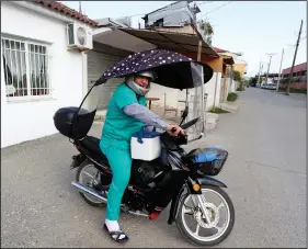  ?? ?? Nurse Ndricim Rahi drives his scooter on his way to administer vaccine shots.