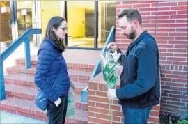  ?? Michael Owen Baker For The Times ?? KATE SWIFT-SPONG and Dalton Combs leave f lowers at USC professor Bosco Tjan’s office after his stabbing death. Combs was a former student of Tjan.