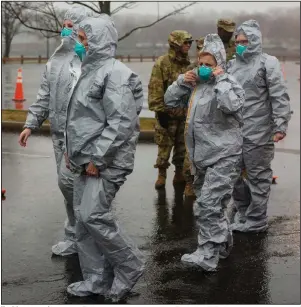  ?? (The New York Times/Andrew Seng) ?? Health care workers arrive Friday at a new center in New Rochelle, N.Y., that was set up as part of the state’s efforts to increase testing capacity for the coronaviru­s.