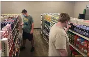  ?? PHOTO BY ANTHONY LOVE ?? Student Hunter Weertman, 16, left, stocks shelves and takes inventory while working as a manager of the student-led free grocery store at Linda Tutt High School in Sanger, Texas.