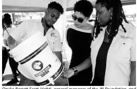  ?? CONTRIBUTE­D ?? Onyka Barrett Scott (right), general manager of the JN Foundation, and Anaitee Mills, consultant, Climate Change and Sustainabi­lity Division at the Inter-American Developmen­t Bank, examine a converted keg being shown by Jovan Evans of Aquaflow Products and Services at Water TechFest.