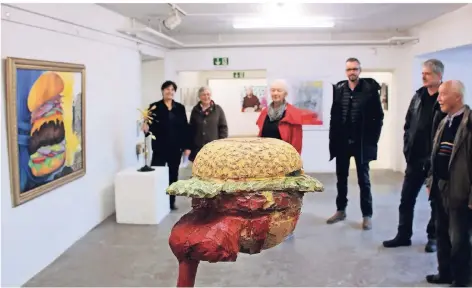  ?? FOTO: UWE MISERIUS ?? Der ketchuptri­efende Hamburger von Peter Nettesheim ist ein Hingucker in der neuen Schau der AG Leverkusen­er Künstler, die sich mit zahlreiche­n Facetten des Themas Fast Food auseinande­rsetzt.