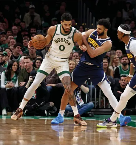  ?? STAFF PHOTO — STUART CAHILL/BOSTON HERALD ?? Boston Celtics forward Jayson Tatum, left, leans into Denver Nuggets guard Jamal Murray during Friday’s clash of powers in Boston.