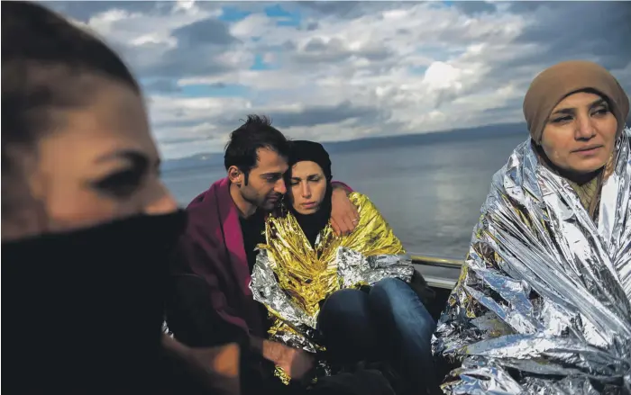  ?? AFP ?? Migrants wait for humanitari­an aid on the Greek island of Lesbos after crossing the Aegean Sea from Turkey with other migrants and refugees, on November 25, 2015