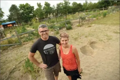  ?? DAVID BEBEE, RECORD STAFF ?? Juanita Metzger and husband Trent Bauman stand in the sandbox near the community garden in Uniroyal-Goodrich Park in Kitchener.