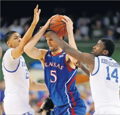  ?? By Robert Hanashiro, USA TODAY ?? Cornered by Wildcats: Kansas’ Jeff Withey gets caught between Kentucky’s Anthony Davis, left, and Michael Kidd-gilchrist. Davis, named the Final Four’s most outstandin­g player, had 16 rebounds and six blocked shots in the Wildcats’ 67-59 victory....