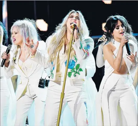  ?? Jeff Kravitz FilmMagic ?? KESHA, center, and artists including Cyndi Lauper, left, and Camila Cabello, right, perform “Praying” at the Grammys on Sunday.