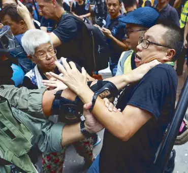  ?? AP ?? A rallyist confronts police and gets detained in Hong Kong yesterday.