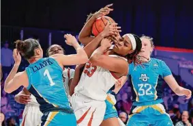  ?? Tim Aylen/Associated Press ?? Texas' Aaliyah Moore fights for possession of the ball against Marquette's Nia Clark during Saturday's game in Paradise Island, Bahamas.