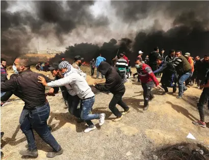  ??  ?? Palestinia­n protesters pull a metal cable as they try to take down a section of the border fence with Israel, east of Gaza City in the central Gaza Strip, on Friday.—