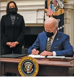  ?? (The New York Times/Anna Moneymaker) ?? President Joe Biden signs executive orders Friday at the White House as Vice President Kamala Harris looks on. Biden’s orders are aimed at helping families struggling during the pandemic and at assuring the safety of workers.