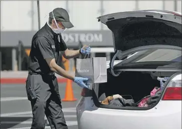  ?? Gary Coronado Los Angeles Times ?? “THE IDEA that stores are dead has been proven to be a fallacy,” one retail analyst said. Above, a Nordstrom employee delivers items to customers waiting in their vehicle at South Coast Plaza in Costa Mesa last year.