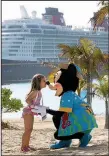  ?? Orlando Sentinel/TNS/JOE BURBANK ?? A guest has a special moment with Minnie Mouse on Castaway Cay, Bahamas, with the Disney Dream in the background.