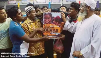  ??  ?? WARGA Rohingya memegang Tabung Sekampit Beras Bantu Rohingya.