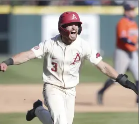  ?? (NWA Democrat-Gazette/Charlie Kaijo) ?? Zack Gregory runs home to score the winning run on Christian Franklin’s single in the 10th inning to give Arkansas a 6-5 victory Saturday at Baum-Walker Stadium in Fayettevil­le. Arkansas won two of three against Auburn to take the series. More photos at arkansason­line.com/44auua/