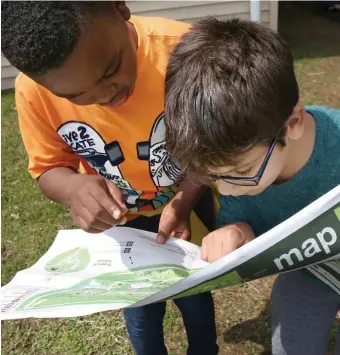  ?? ANGELA ROWLINGS PHOTOS / HERALD STAFF ?? LOOKING FOR ADVENTURE: Kenny Ndive, 9, left, and Emmanuel Brollo Teixeira, 10, look over a map together Monday at the Franklin Park Zoo at an event with incoming Boston Public Schools Superinten­dent Brenda Cassellius and Mayor Martin Walsh.