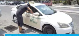  ??  ?? KUWAIT: A man talks to a taxi driver at a street in Salmiya. — Photo by Fouad Al-Shaikh