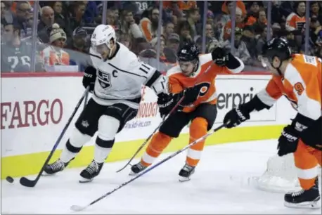  ?? MATT SLOCUM — THE ASSOCIATED PRESS ?? Kings center Anze Kopitar moves the puck along the boards while the Flyers Jordan Weal (40) and Ivan vain Monday night during the Kings’ 4-1 victory at Wells Fargo Center. Provorov chase in