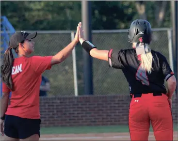  ??  ?? LFO’s Karson Bradford gets a hand from assistant coach Lauren Dyer after getting a hit against Ringgold last week. The Lady Warriors will host Haralson County on Tuesday in the opening round of the Region 6-AAA tournament. (Photo by Scott Herpst)