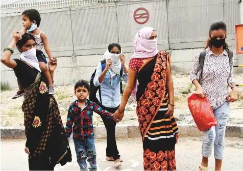  ?? ANI ?? Migrant families at Anand Vihar in New Delhi as they move towards their native places yesterday.