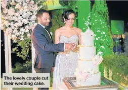  ??  ?? The lovely couple cut their wedding cake.