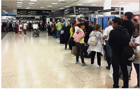  ?? — AFP ?? Hurry up and wait: Travellers at Miami Internatio­nal Airport waiting in line to enter the checkpoint at Concourse F, where some flights of a closed terminal were diverted, in Miami, Florida.