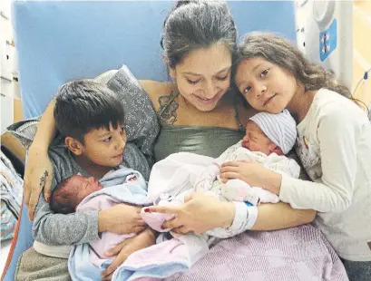  ?? STEVE RUSSELL TORONTO STAR ?? Melissa Arrubla and her two eldest children Anderson, 7, and Cataleya, 6, hug their new brother Elian and sister Elena. “We started our new year with a bang,” Arrubla said. “What happened was surreal, but I’m glad we’re here and everyone is OK.”