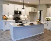  ?? ?? In the kitchen, an island has an extended quartz counter that allows for breakfast seating for up to four.