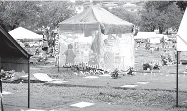  ?? PNA photo ?? TENTS and covers, including one made of canvas and mosquito net, serve as shades for visitors of tombs at the Loyola Memorial Park in Marikina City, as the country observes All Saints’ Day. At least 100,000 people are expected to visit the cemetery during this year’s observance of Undas.