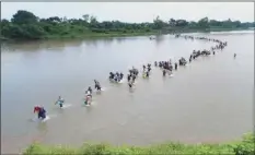  ??  ?? In this November file photo, Salvadoran migrants cross the Suchiate River near Tecun Uman, Guatemala, the border with Mexico, as the caravan of Central American migrants make its way north with the stated purpose of entering the United States. Mexico will end the practice of undocument­ed or illegal crossings over the Suchiate River, which marks much of the border between the two countries, Mexico’s Interior Secretary Olga Sanchez Cordero said on Wednesday. AP PHOTO/OSCAR RIVERA