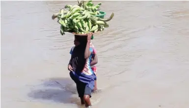  ?? Abubakar Sadiq Isah ?? Two young women waddle through a river at Rubokya village, on their way to Kwaku Market in Kuje Area Council of the FCT yesterdayP­hoto: