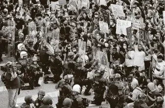  ?? Curtis Compton / Atlanta Journal-Constituti­on via AP ?? While these law enforcemen­t officers knelt in solidarity with protesters Monday in Atlanta, some other officers across the nation have been accused of using heavy-handed tactics.